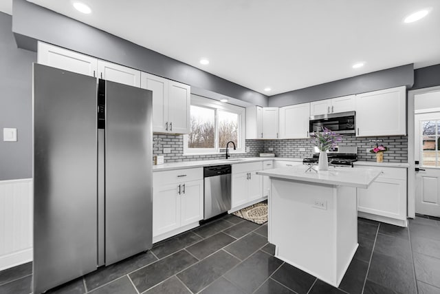 kitchen featuring white cabinetry, a healthy amount of sunlight, appliances with stainless steel finishes, and a center island