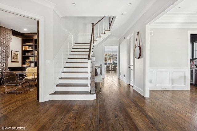 stairway featuring crown molding, hardwood / wood-style floors, and built in shelves