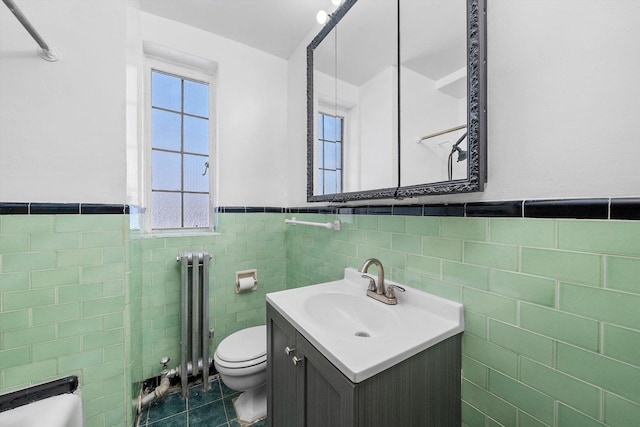 bathroom with a wealth of natural light, radiator heating unit, tile patterned flooring, and toilet