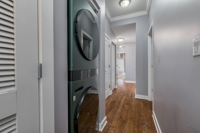 laundry area featuring stacked washer and dryer, crown molding, and dark hardwood / wood-style flooring