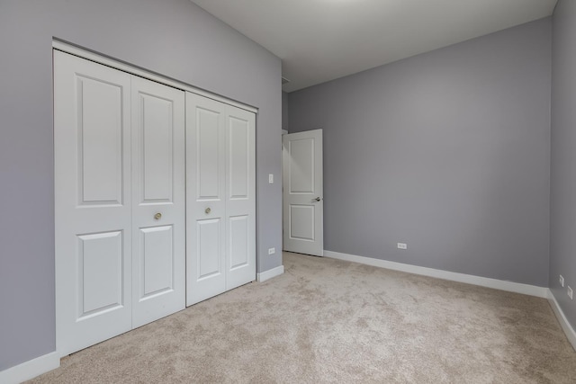 unfurnished bedroom with a closet and light carpet