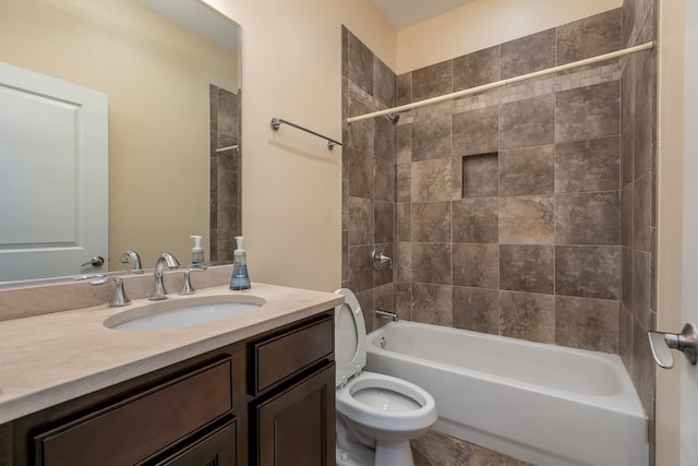 full bathroom featuring tiled shower / bath, vanity, and toilet