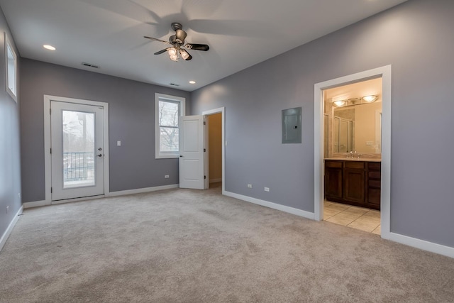 unfurnished bedroom featuring connected bathroom, sink, access to outside, electric panel, and light colored carpet