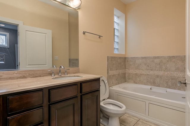 bathroom featuring a washtub, vanity, tile patterned floors, and toilet