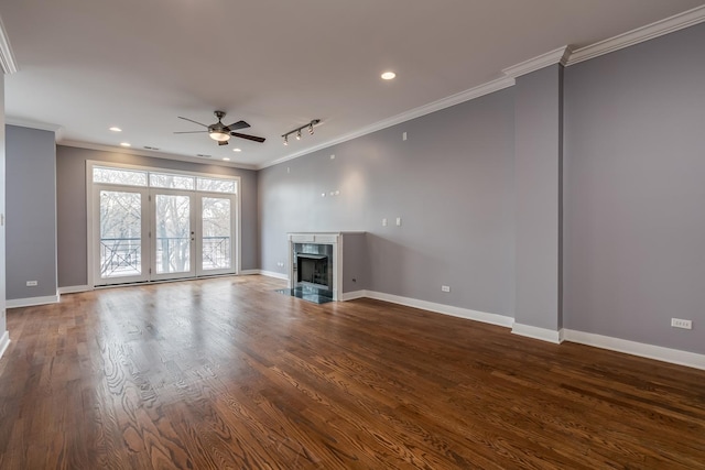 unfurnished living room with hardwood / wood-style flooring, rail lighting, ceiling fan, a fireplace, and ornamental molding