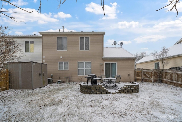 snow covered rear of property with a shed and central air condition unit