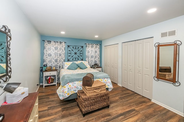 bedroom featuring visible vents, two closets, wood finished floors, recessed lighting, and baseboards