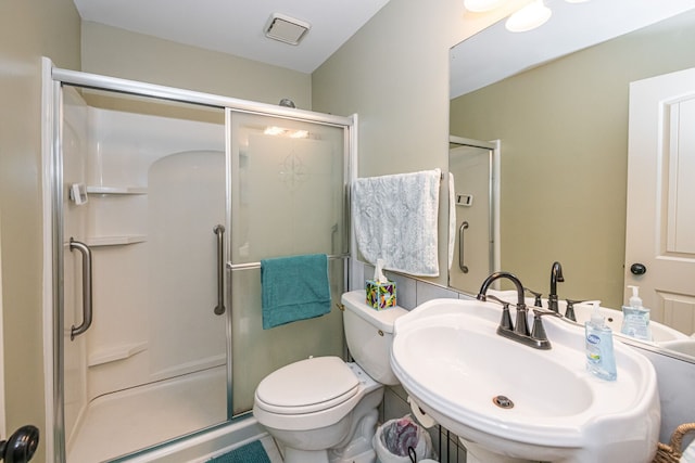 full bathroom featuring a sink, toilet, and a shower stall