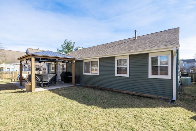 back of property featuring a patio, fence, a yard, a shingled roof, and a gazebo