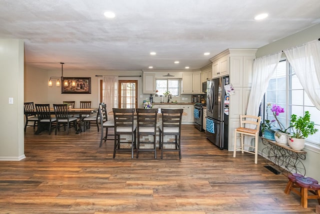 dining area with dark wood-type flooring, recessed lighting, and visible vents