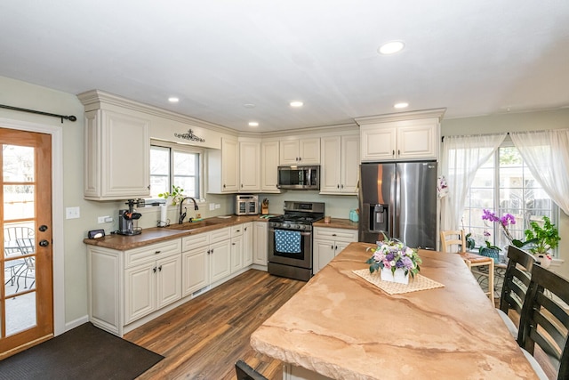 kitchen featuring a sink, dark wood-style floors, recessed lighting, stainless steel appliances, and white cabinets