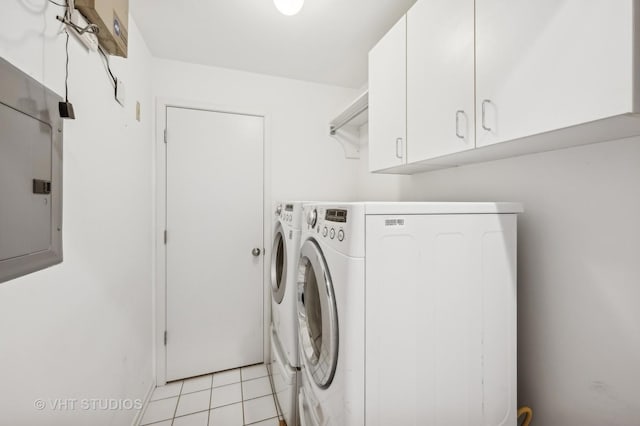 laundry room featuring light tile patterned floors, washing machine and dryer, cabinet space, and electric panel