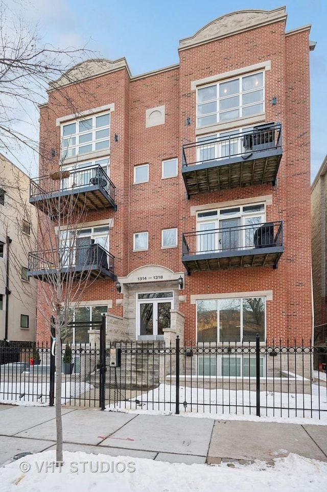 snow covered building with a fenced front yard