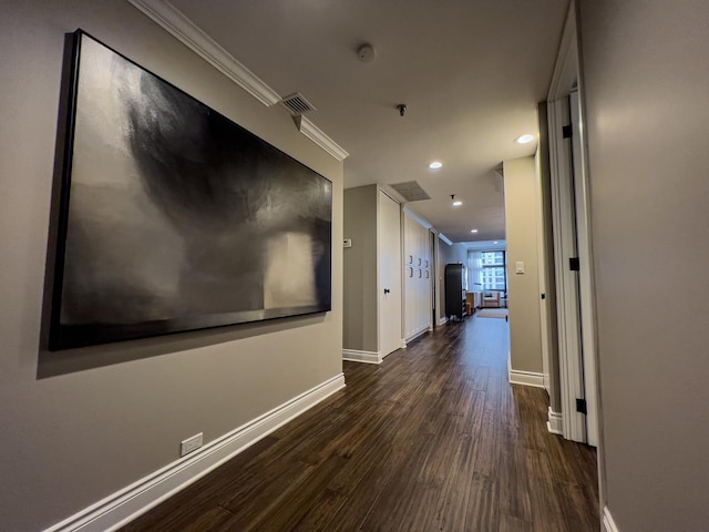 hallway featuring ornamental molding and dark hardwood / wood-style flooring