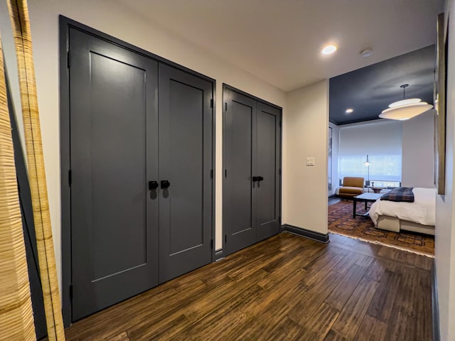 bedroom featuring dark hardwood / wood-style flooring and multiple closets