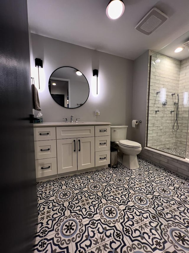 bathroom featuring walk in shower, vanity, toilet, and tile patterned flooring