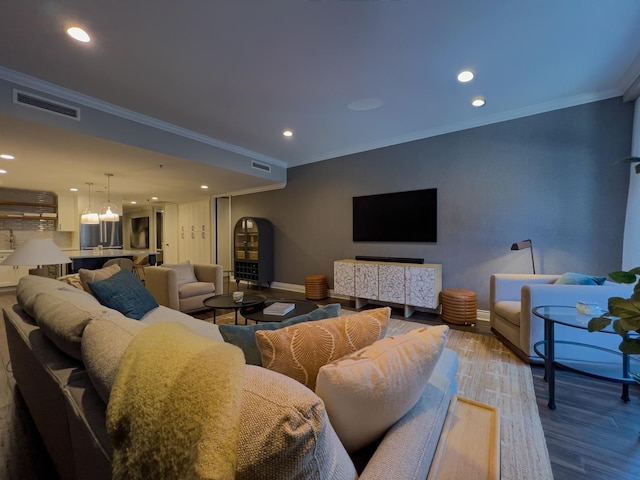 living room with crown molding and hardwood / wood-style flooring