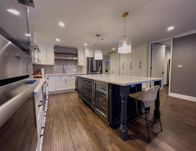 kitchen featuring white cabinetry, a center island, dark hardwood / wood-style floors, stainless steel fridge, and pendant lighting