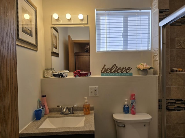 bathroom featuring vanity, toilet, and walk in shower