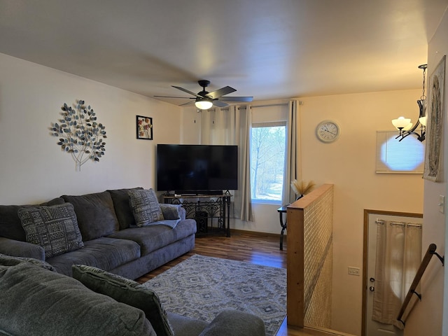 living room with ceiling fan with notable chandelier and dark hardwood / wood-style floors