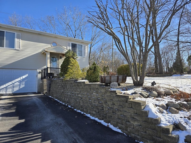 view of snow covered exterior with a garage