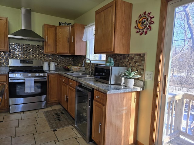 kitchen with sink, tasteful backsplash, stainless steel appliances, beverage cooler, and wall chimney range hood