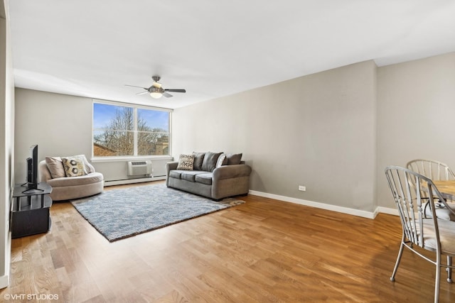 living room featuring a wall mounted air conditioner, ceiling fan, baseboard heating, and wood-type flooring