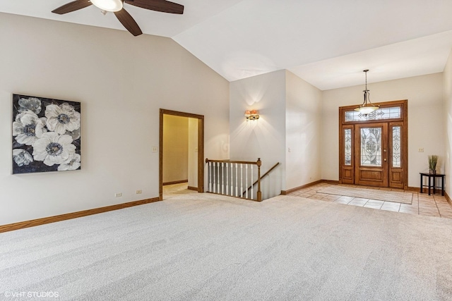 foyer featuring light carpet, high vaulted ceiling, light tile patterned flooring, and baseboards