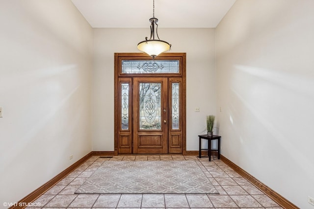 foyer featuring light tile patterned flooring and baseboards