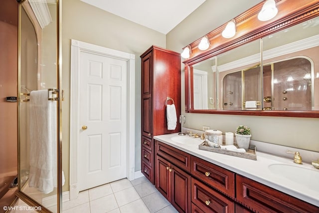 bathroom with double vanity, a shower with door, a sink, and tile patterned floors