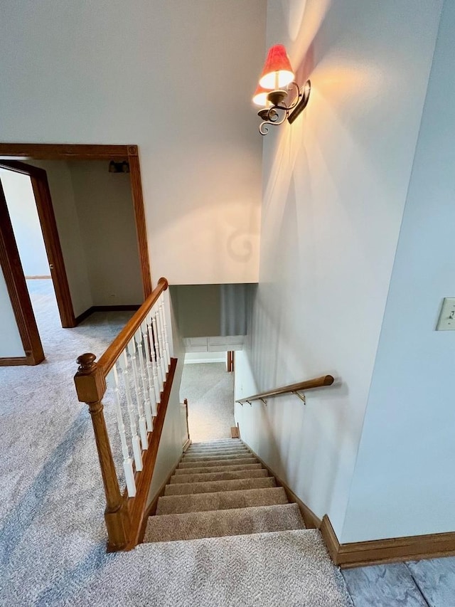 stairway with carpet floors and baseboards