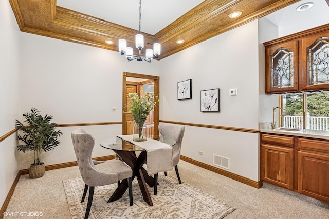 dining room with light colored carpet, visible vents, crown molding, and an inviting chandelier