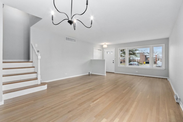 unfurnished living room with a chandelier and light hardwood / wood-style floors