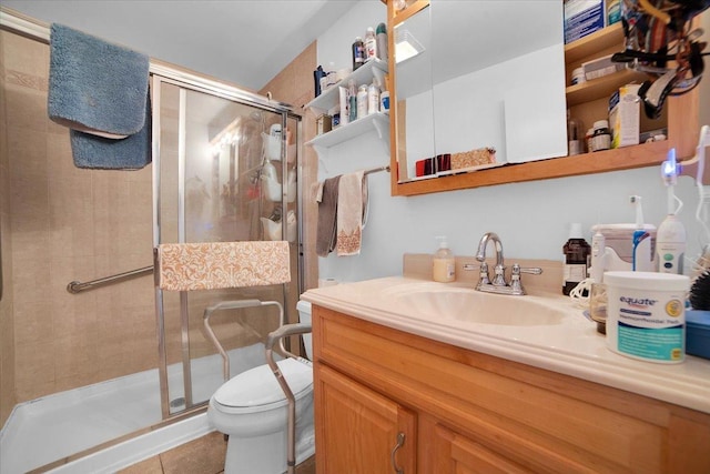 bathroom with vanity, toilet, and a shower with door