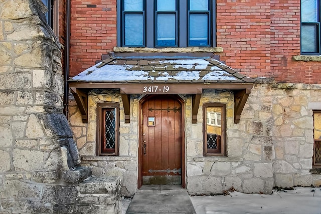 entrance to property with brick siding and stone siding