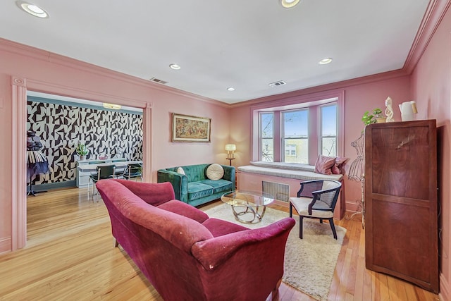 living room featuring light wood finished floors, ornamental molding, visible vents, and recessed lighting