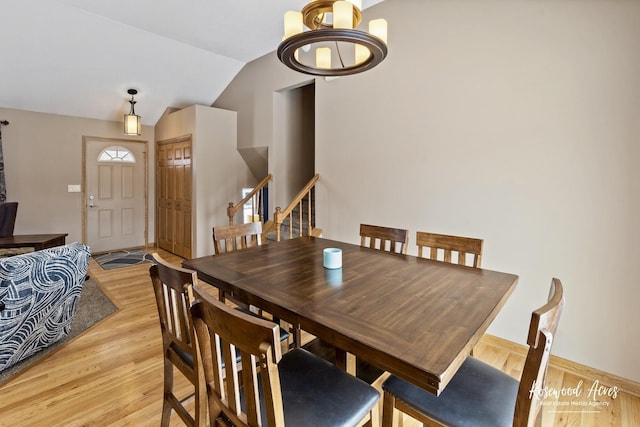 dining space featuring stairway, lofted ceiling, and light wood-style floors