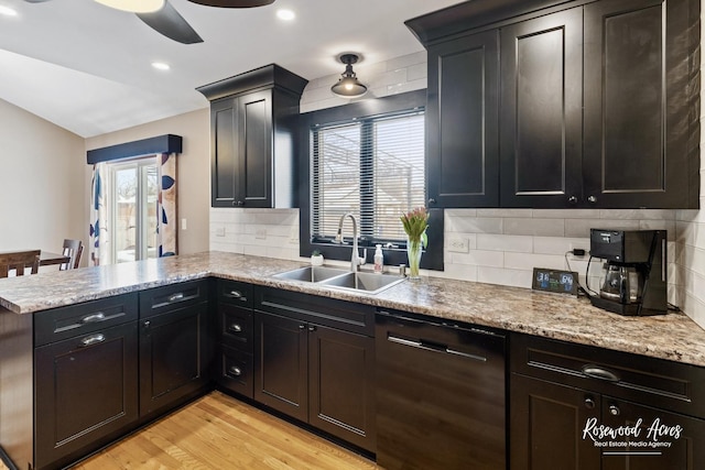 kitchen with a peninsula, a sink, decorative backsplash, light wood-style floors, and dishwasher