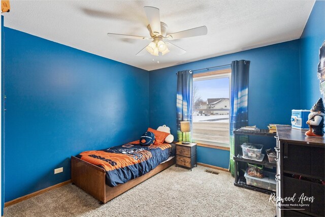 bedroom with baseboards, carpet, ceiling fan, and a textured ceiling