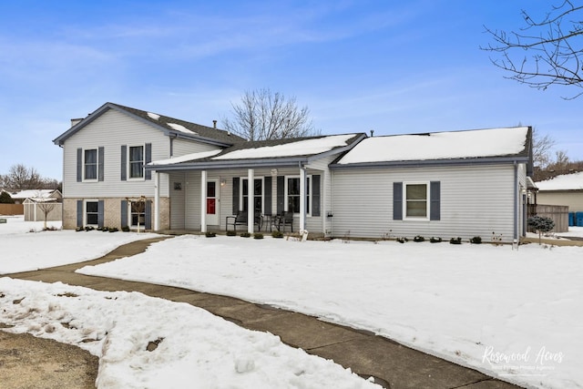 tri-level home featuring brick siding and covered porch