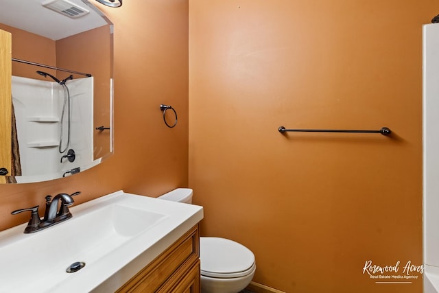 full bath featuring vanity, toilet, a shower, and visible vents