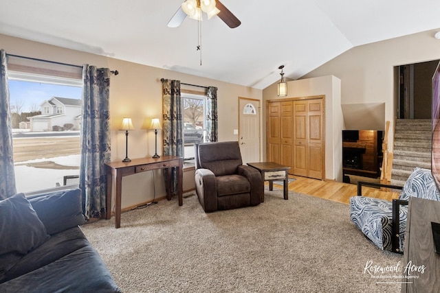 living area featuring stairway, ceiling fan, and lofted ceiling