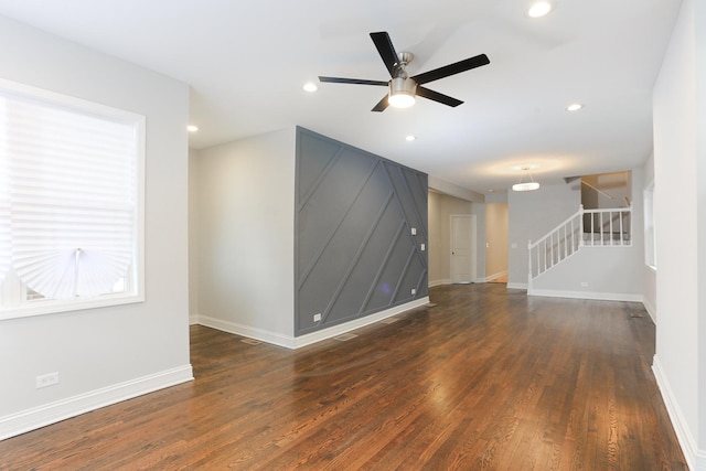 unfurnished living room with dark hardwood / wood-style floors and ceiling fan