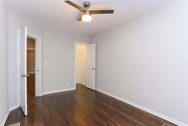 unfurnished bedroom featuring ceiling fan and dark hardwood / wood-style flooring