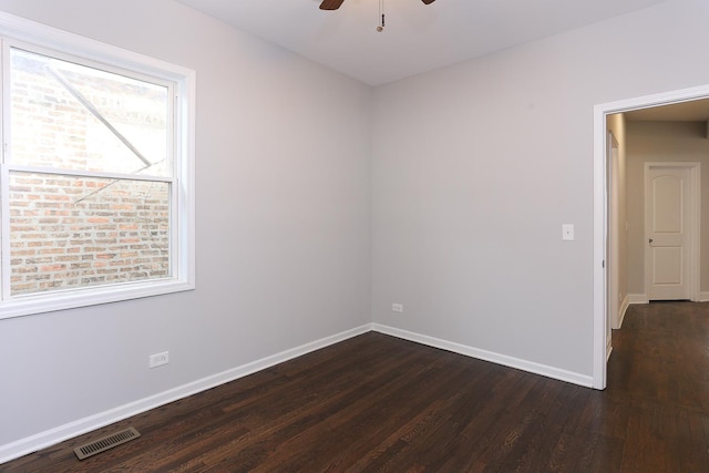 empty room with ceiling fan and dark hardwood / wood-style flooring