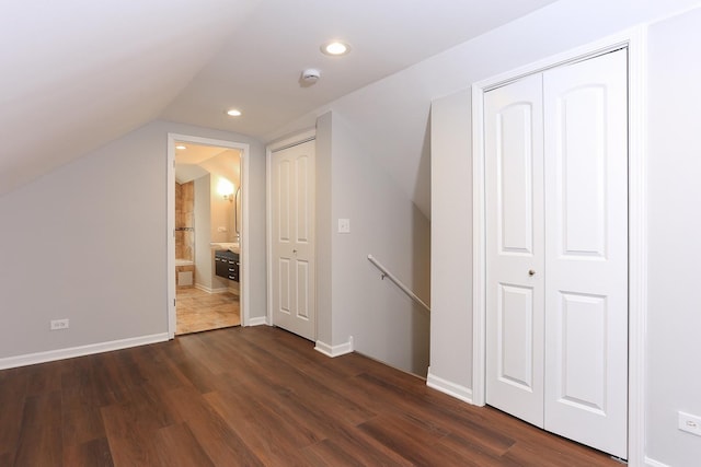 bonus room with dark wood-type flooring and vaulted ceiling