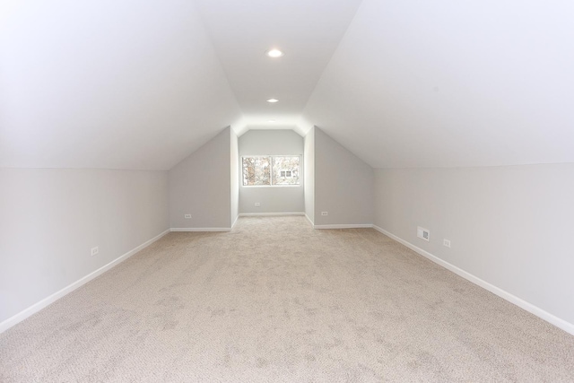 additional living space with vaulted ceiling and light carpet