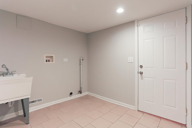 washroom with light tile patterned flooring and hookup for a washing machine