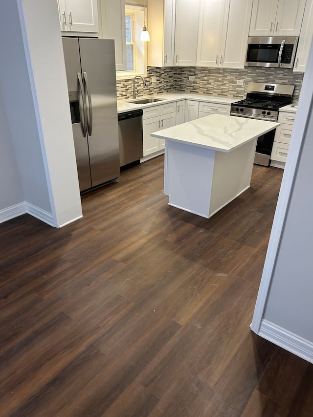 kitchen with pendant lighting, sink, white cabinetry, and stainless steel appliances