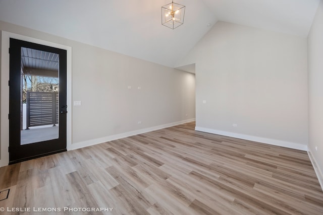 entrance foyer with high vaulted ceiling, a notable chandelier, and light hardwood / wood-style floors